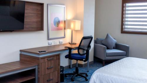 a hotel room with a desk and a chair and a television at Holiday Inn Express & Suites - Ciudad Obregon by IHG in Ciudad Obregón