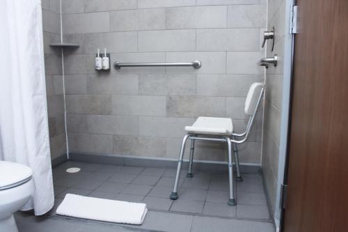 a shower with a chair in a bathroom at Holiday Inn Express & Suites - Ciudad Obregon by IHG in Ciudad Obregón