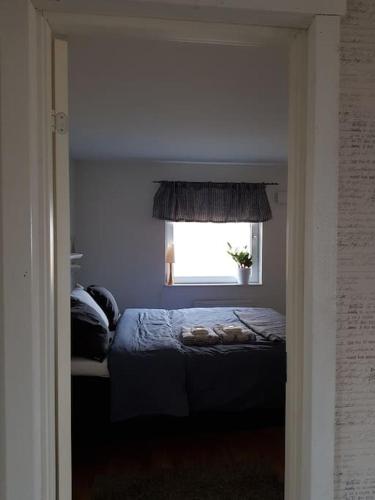 a bedroom with a bed and a window at Ekbacken - naturskön stuga med närhet till havet in Nyköping