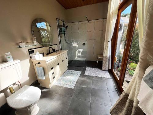 a bathroom with a sink and a toilet and a shower at Stony Rise Cottage B&B in Devonport