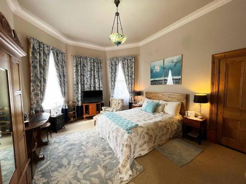 a bedroom with a bed and a living room at Stony Rise Cottage B&B in Devonport