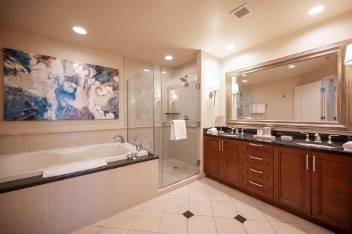 een badkamer met een bad, een douche en een wastafel bij No Resort Fee Strip View Suite +Free Valet + Pool in Las Vegas