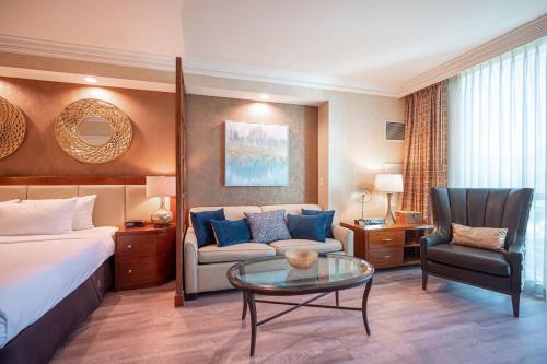 een hotelkamer met een bed, een bank en een tafel bij No Resort Fee Strip View Suite +Free Valet + Pool in Las Vegas