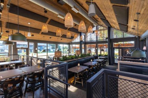 een restaurant met tafels, stoelen en ramen bij Best Western Plus Tin Wis Resort in Tofino