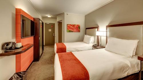 a hotel room with two beds and a television at StayEasy Eastgate in Johannesburg