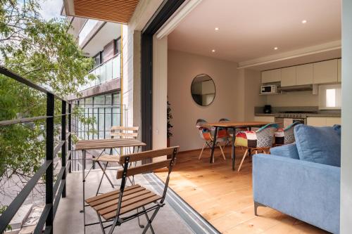 an open balcony with a blue couch and a table at Apartamentos Boutique La Condesa in Mexico City