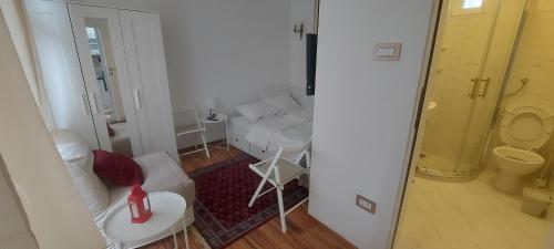 ein weißes Wohnzimmer mit einer Couch und einem Tisch in der Unterkunft Tsar Dušan Apartment in Belgrad