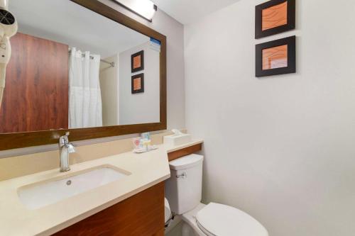 a bathroom with a toilet and a sink and a mirror at Comfort Inn Airport in Manchester