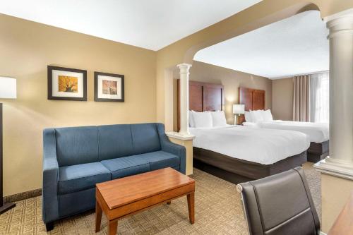 a hotel room with two beds and a blue couch at Comfort Inn & Suites Dover-Portsmouth in Dover