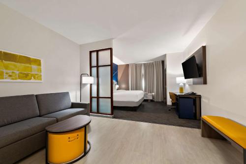 een hotelkamer met een bank en een bed bij Comfort Suites in Bastrop