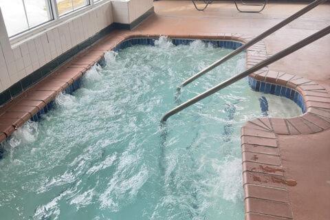 a swimming pool with water in a building at Duluth Inn & Suites Near Spirit Mountain in Duluth