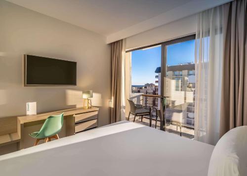 a hotel room with a bed and a large window at Occidental Fuengirola in Fuengirola