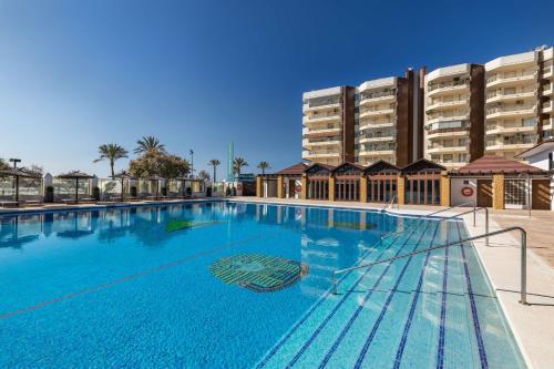 a large swimming pool in front of a large building at Occidental Fuengirola in Fuengirola