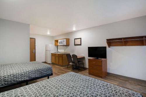 a hotel room with two beds and a television at WoodSpring Suites Greenville Central I-85 in Greenville