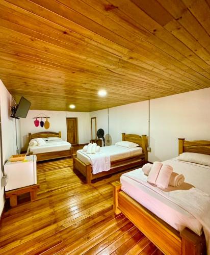 a bedroom with two beds and a wooden ceiling at Hotel Campestre la Playa in Betania