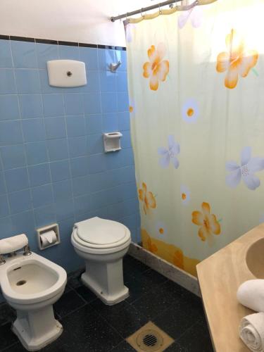 a bathroom with a toilet and a shower curtain at Hotel Gaudí in Punta del Este