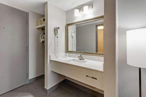 a bathroom with a sink and a mirror at Clarion Pointe by Choice Hotel in Erie
