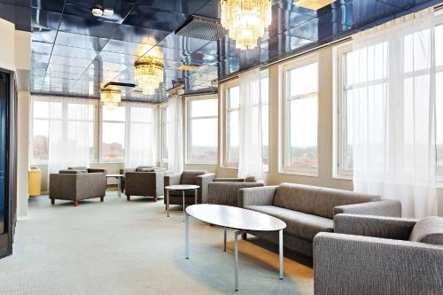 a waiting room with couches and tables and windows at Best Western Plus Skogshöjd in Södertälje