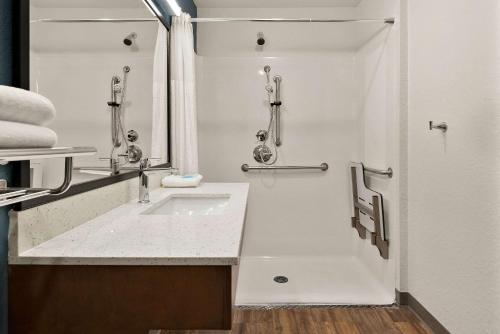 y baño con lavabo y ducha. en WoodSpring Suites Port Orange - Daytona Beach, en Port Orange