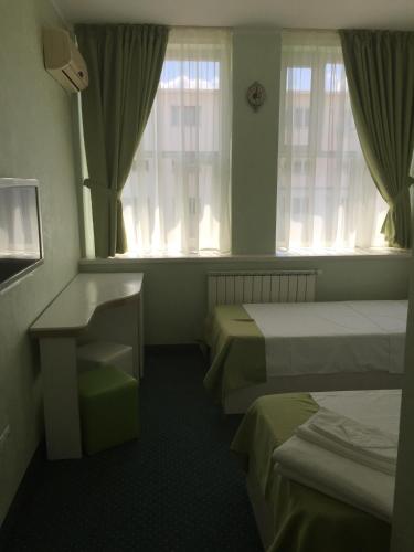 a hotel room with two beds and a window at Hamlet Hotel in Bacău