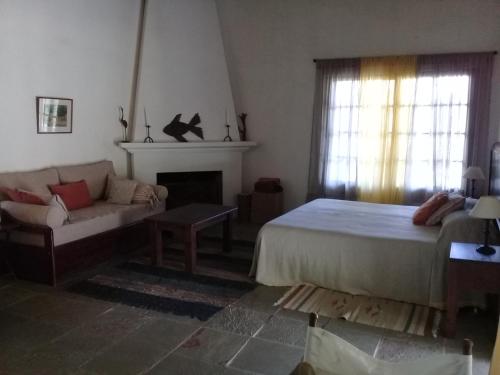 1 dormitorio con cama, sofá y chimenea en Sierra de Mariscala, en Mariscala