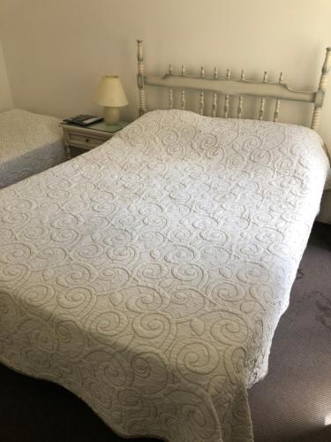 a bed with a white comforter in a bedroom at Hotel Gaudí in Punta del Este