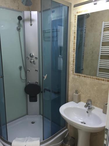 a bathroom with a sink and a shower at Hamlet Hotel in Bacău