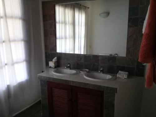 un bagno con due lavandini e un grande specchio di Sierra de Mariscala a Mariscala
