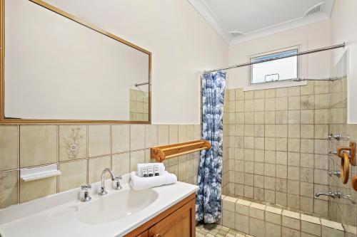 a bathroom with a sink and a shower at Leafy Family House, Close to Beach and Surf Club in Macmasters Beach