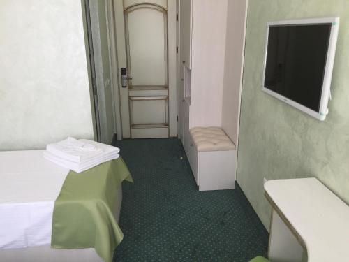 a small room with a bed and a television at Hamlet Hotel in Bacău