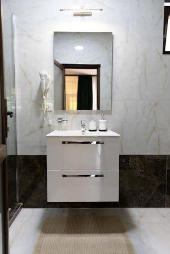 a white bathroom with a sink and a mirror at ANCA in Saturn