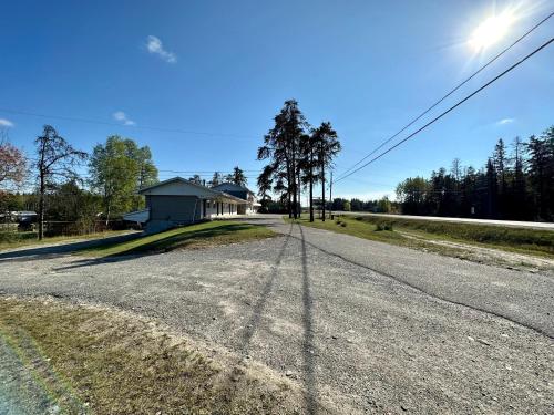 uma estrada vazia em frente a uma casa em Pine Ridge Motel em Timmins