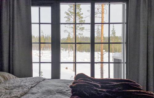 a bedroom with a window looking out at a snow covered yard at Beautiful Apartment In Idre With House A Panoramic View in Idre