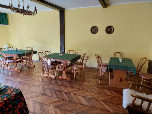 a room with tables and chairs and a clock on the wall at Słotwińska 14 in Krynica Zdrój