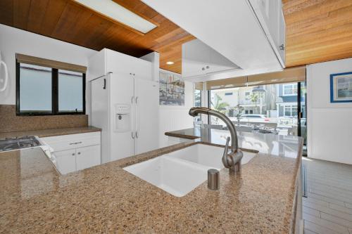 een keuken met witte kasten en een wastafel bij 4 bedroom Home in Quiet Neighborhood near Beach in Newport Beach