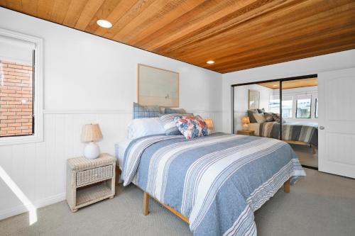 een slaapkamer met een bed en een spiegel bij 4 bedroom Home in Quiet Neighborhood near Beach in Newport Beach