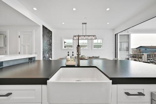 een witte keuken met een groot wit aanrecht bij 4 Bedrooms in BRAND NEW Luxury built Home walk to the beach in Newport Beach