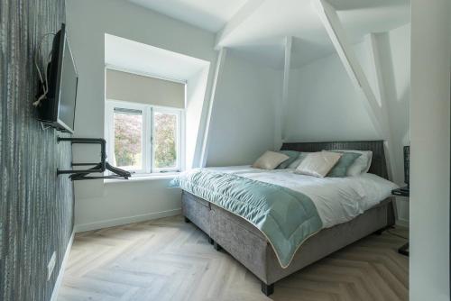 een slaapkamer met een bed en een raam bij Lovely Apartment With Workspace Jack Nr 5 in Roosendaal