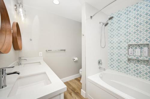 a bathroom with a sink and a tub and a shower at Brand New Modern Home by the Beach with Patio & BBQ in Newport Beach