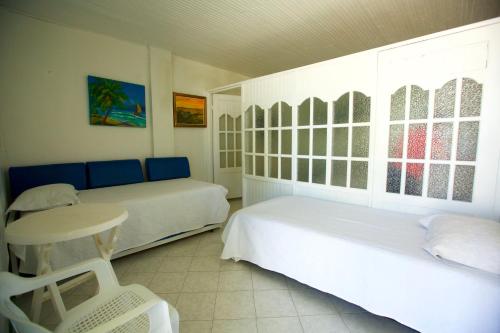 1 dormitorio con 2 camas y mesa. en Posada Dima Cresida, en San Andrés