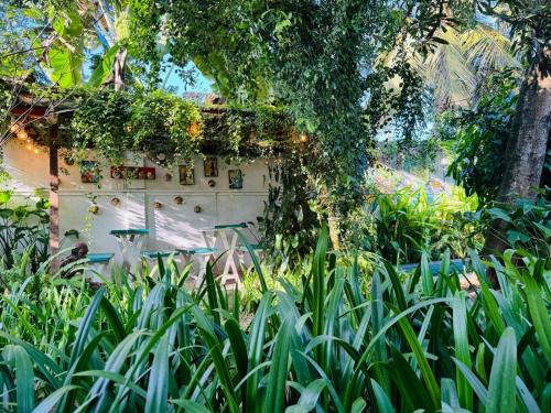 a building with ivy on it in a garden at Double Mango Villa in Katunayake