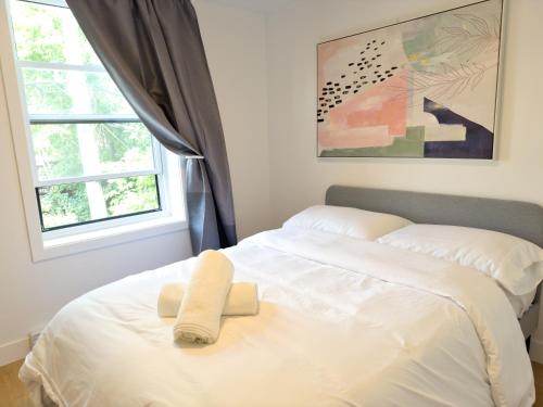 1 cama blanca con 2 toallas en un dormitorio en Gorgeous Renovated 3 BedR Downtown 2mins to Metro!, en Montreal