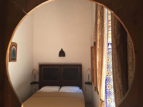 a bedroom with a bed and a round window at Riad Marhaba in Rabat