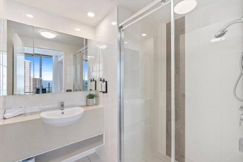 a white bathroom with a sink and a shower at Spectacular Views from Wyndham Apartment in Gold Coast