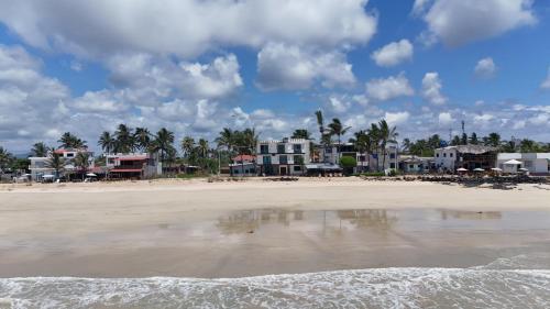 a group of houses on a beach near the water at Hotel Sierra Negra in Puerto Villamil