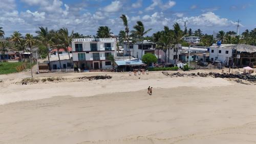 a group of people standing on a sandy beach at Hotel Sierra Negra in Puerto Villamil