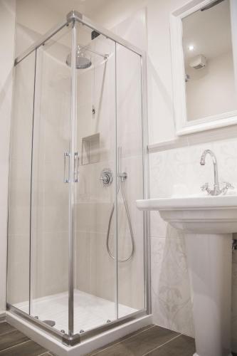 a shower with a glass door next to a sink at Tornabuoni View in Florence