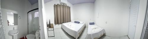 Nathus Hotel في Chapadão do Sul: حمام أبيض مع حوض ومرحاض