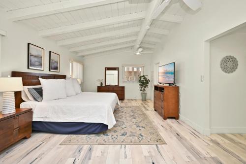 um quarto com uma cama e uma televisão em Beachfront home with Sweeping Ocean Views, AC, Walk to the Pier, Restaurants, Shops, Activities em Newport Beach