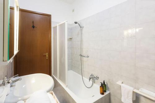 a bathroom with a tub and a sink and a shower at Loft alto con vista su Città Alta in Bergamo
